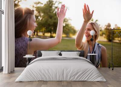 Young women in park having fun together Wall mural