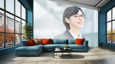 スーツ姿で笑顔を見せる若い女性 Wall mural