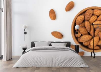 Almond in wooden bowl isolated on white background. Top view Wall mural