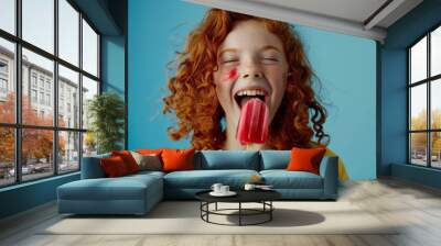 Child happily enjoys a sweet ice cream treat.  Cheerful teen curly red hair catching autumn sunlight. Warmth of free spirit complemented season's colors. Wall mural