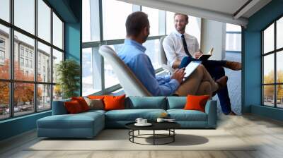 Business colleagues smiling and talking together in modern office Wall mural