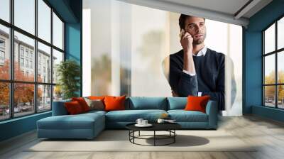 Businessman talking on his phone while standing in his office Wall mural