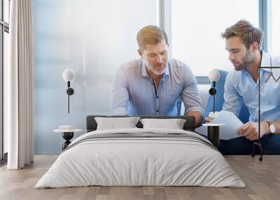 mature businessman talking with younger colleague on couch Wall mural