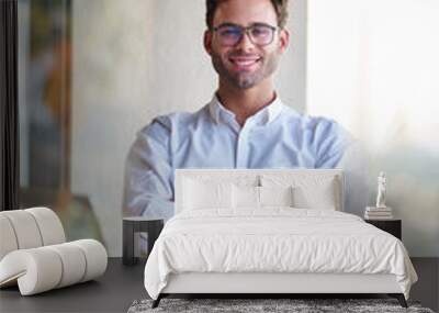 Smiling young businessman working at a table at home Wall mural