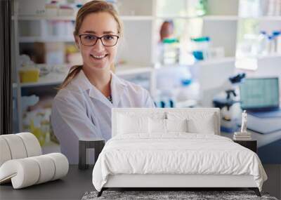 Smiling young female technician standing in a lab Wall mural