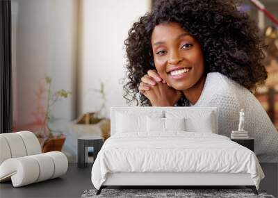 Young African American woman smiling while sitting in a cafe Wall mural