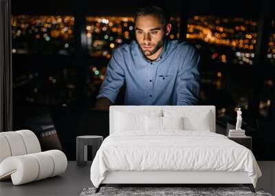 Young businessman working late at night on a laptop Wall mural