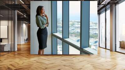 Young executive deep in thought looking through office tower windows Wall mural