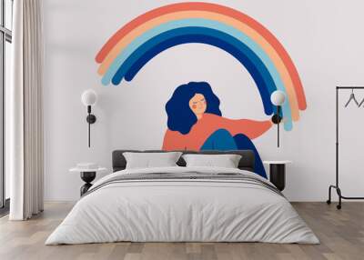 Happy woman sits on the floor and draws her arms to the rainbow. Smiled girl creates good vibe around her. Smiling female character enjoys her freedom and life. Body positive and health care concept Wall mural