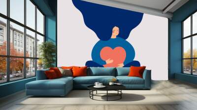 Young woman embraces a big red heart with mindfulness and love. Smiling female character sits in lotos pose with closed eyes and enjoys her freedom and life. Body positive and mental health concept. Wall mural