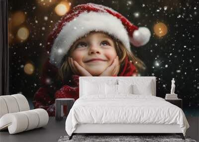 Adorable child in a Santa Claus hat closeup of face Christmas card style with snow and festive bokeh lights background with copy space.nostalgic childhood children kids holiday magic of Christmas Wall mural