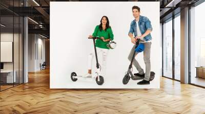 a couple riding on electic kick scooter isolated on white studio background Wall mural