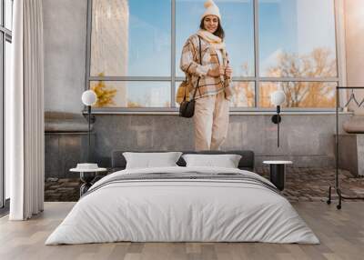 young smiling woman walking in street in winter Wall mural