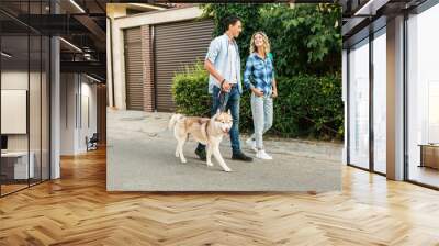 young stylish couple walking with dog in street, man and woman happy together Wall mural