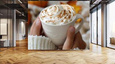 Woman holding cup of tasty pumpkin spice latte with whipped cream at white table, closeup Wall mural