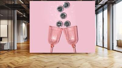 Glasses and shiny disco balls on pastel light pink background. Minimalistic party concept. Creative birthday composition. Wall mural