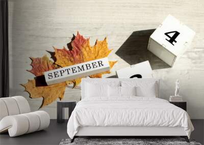 Calendar for September 24 : the name of the month of September in English, cubes with the number 24, two maple leaves on a gray background in the sun, shadows from objects, top view Wall mural