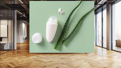 Roll on antiperspirant deodorant, two fresh aloe leaves and sea shell butterfly over pastel green background. Organic herbal toiletries and natural cosmetics for body care concept. Wall mural