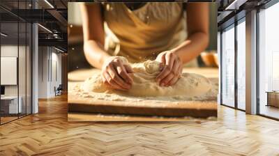 Mothers hands expertly kneading bread dough on a wooden table Wall mural