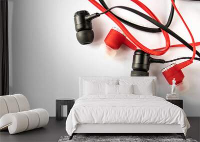 Red and black headphones with headset lie on a white background isolated Wall mural