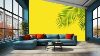 Green leaf of palm tree on yellow background Wall mural