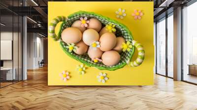 Top view, flat lay. Easter still life. Rustic brown eggs in a wicker basket lined with checkered fabric. Wall mural