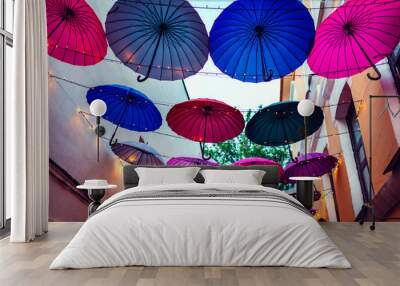 City street decorated with umbrellas and lights. Architecture exterior design in the evening. Wall mural