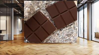 a bar of a dark chocolate in a silver wrap Wall mural