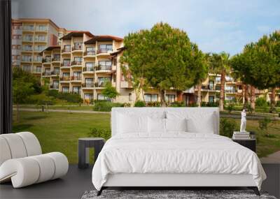 hotel with thatched cottages on the beach in the shade of palm t Wall mural