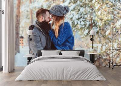 happy loving couple walking in snowy winter forest, spending christmas vacation together. Outdoor seasonal activities. Lifestyle capture. Wall mural