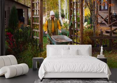 seasonal autumn garden work. Woman gardener at wooden pergola with wheelbarrow. Natural country living Wall mural