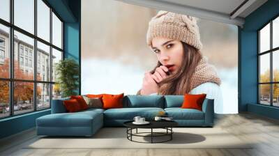 winter close up portrait of beautiful young woman in knitted hat and sweater walking in snowy park or forest, spending weekend outdoo Wall mural