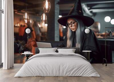 Young halloween witch working on a laptop computer, witch job, ai generated Wall mural