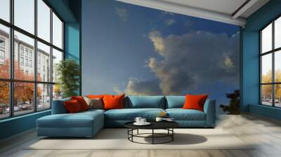 A bright sunset with heavy rain clouds in the sky. Evening sunrise and sunset in the background. Wall mural