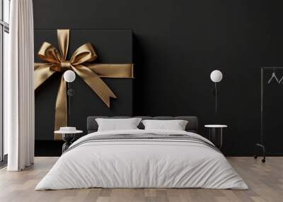 Black gift box with gold ribbon and bow, perfect for holiday greeting cards, luxury gift ideas, festive event invitations, and elegant presentations. Wall mural