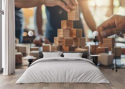 Business people constructing a tower with wooden blocks symbolizing teamwork Wall mural