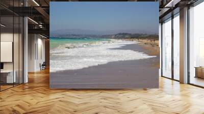 evocative image of a sandy beach with a sea of many colors and clear skies
 Wall mural