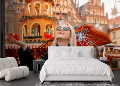 Blond hair woman in sunglasses near Christmas fair decorations in Wroclaw, Poland. 2021 Wall mural