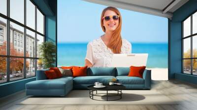 Cute woman with white laptop on the summer beach Wall mural