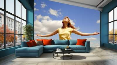 Girl at blue sky background. Wall mural