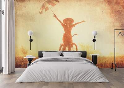 Girl with umbrella on a bike in the countryside in sunrise time Wall mural