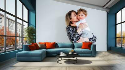 Mother and son on a white wall background at home Wall mural