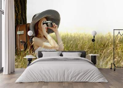 redhead girl sitting near tree with vintage camera. Wall mural