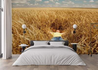 Redhead girl sleeping at wheat field at summertime. Wall mural