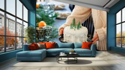 Woman holding christmas cake with cream over a table Wall mural