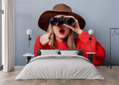 woman in red sweater and hat with binocular Wall mural