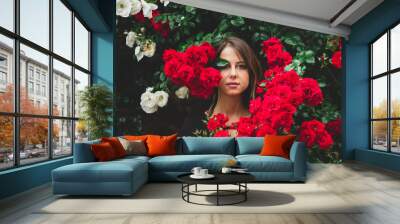 young girl near the bush of red and white roses Wall mural