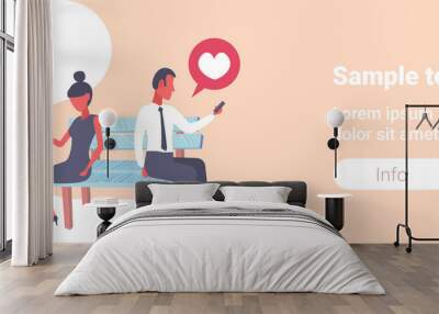 couple sitting wooden bench back to back using smartphone chat bubble communication concept man woman chatting cell phone ignoring each other flat horizontal full length copy space Wall mural