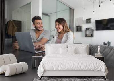 couple use laptop computer sitting at table in modern apartment together young man and woman surf in Wall mural