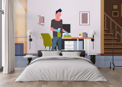 man cleaning computer table with duster guy wiping workplace desk housework concept modern living room interior male cartoon character full length horizontal Wall mural